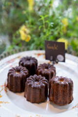 Caneles de bordeaux - traditional French sweet dessert on a white plate