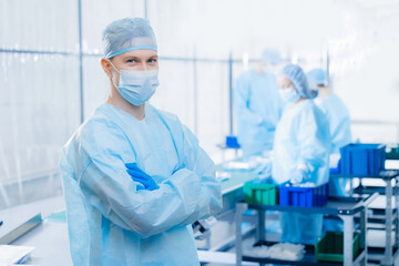 Portrait medicine factory worker scientist background on conveyor line of pharmacy. Medical man working research in pharmaceutical industry, blue light