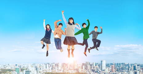 都市を背景にジャンプする学生のグループ