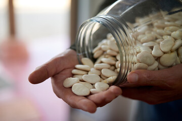 A clear glass jar filled with large heirloom beans, emphasizing their substantial size and natural...