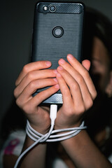 Young girl at night communicates on Internet. Child gadget addiction and insomnia. Anxiety and sleep deprivation as the side effects of internet addiction. Vertical image.
