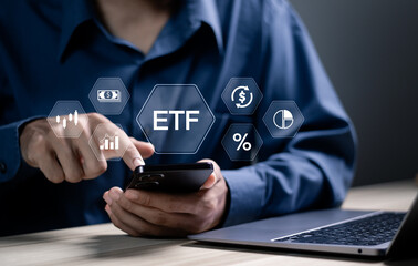 ETF, Exchange traded fund concept. Business stock market finance index fund. Businessman using smartphone and laptop with ETF icons on virtual screen.