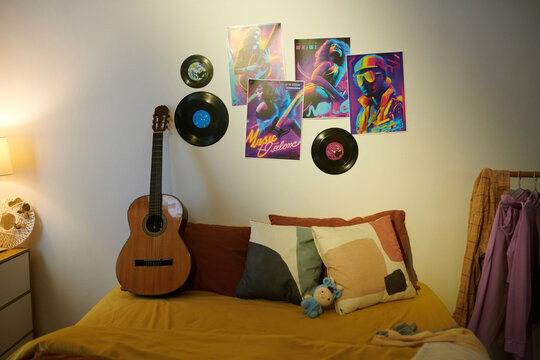 Music band posters and vinyl records on wall in bedroom of teenager