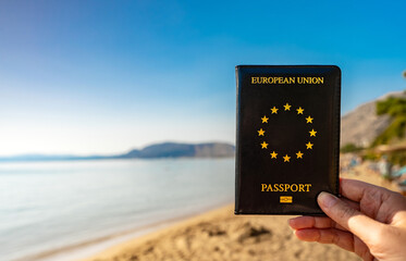 Man holding EU passport against the backdrop of a tropical country.