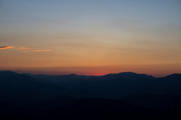 Fototapeta premium Silhouette of the hills at sunset with hazy sky.