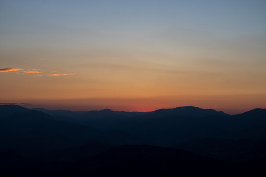 Silhouette of the hills at sunset with hazy sky.
