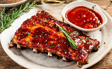 Grilled pork ribs with grill sauce, with smoke, spices and rosemary - obrazy, fototapety, plakaty