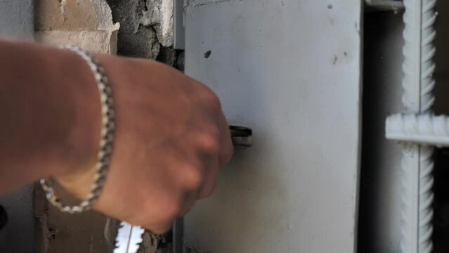 Closing an iron door. close-up of hands with keys closing the lock in the door