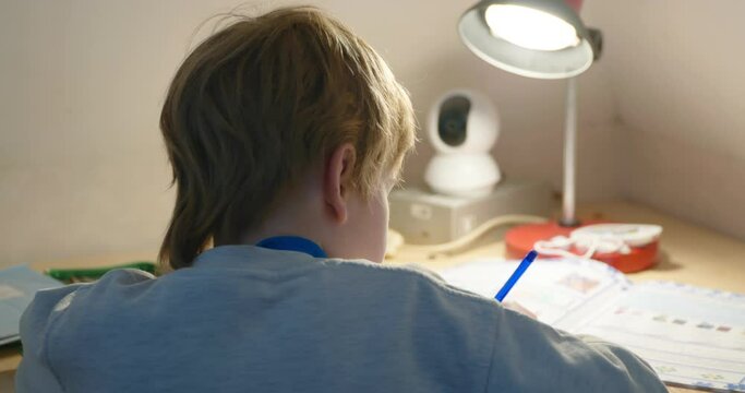 Kid Boy Study at Home. Schoolboy Doing Homework Sitting at Desk Table. 4K 10-bit