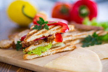 fried toast with chicken, salad, greens on a wooden table