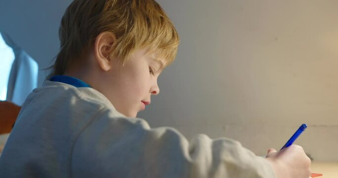 Kid Boy Study at Home. Schoolboy Doing Homework Sitting at Desk Table. 4K 10-bit