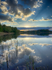 Serene Fishing Lake: A peaceful scene by the tranquil waters of a secluded fishing lake. Surrounded...
