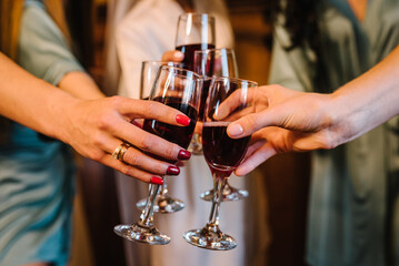 Cheers. Cheerful girls celebrating bachelorette party closeup. Bridesmaids clinking glasses of...