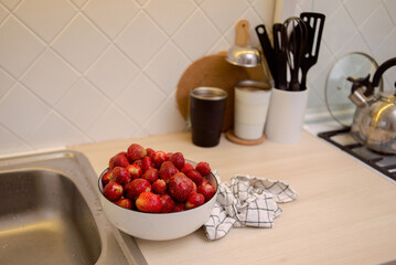 plate with fresh strawberries on the kitchen counter