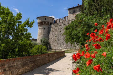 A medieval castle sturdy stone walls and the Torre dei prigionieri tower rise in Brescia, framed by...