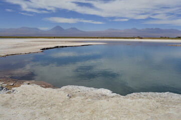 Paisagem de lagoa com cordilheiras ao fundo