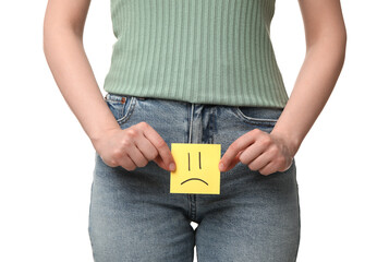 Cystitis. Woman holding sticky note with drawn sad face on white background, closeup