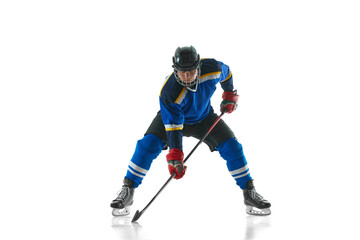Focused professional hockey player stickhandling in motion against white studio background. Concept of professional sport, competition, movement, energy, match, tournament. Ad