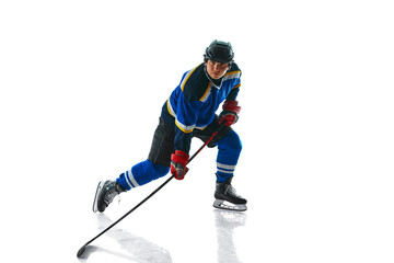 Focused professional hockey player with stick showing of puck control against white studio background. Concept of professional sport, competition, movement, tournament, match, healthy lifestyle. Ad