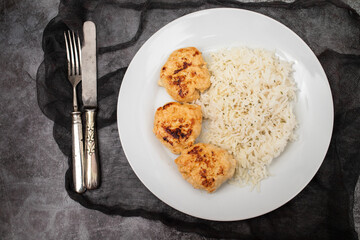 Fried chicken meatballs with boiled rice on plate