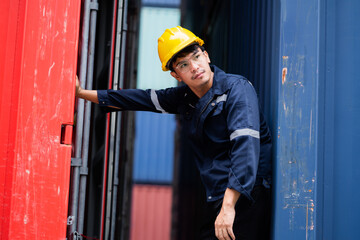 A man in a yellow hard hat is leaning against a red wall. He is tired and possibly injured