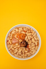 fabada asturiana, a typical spanish bean stew in white bowl