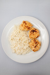 Fried chicken meatballs with boiled rice on plate