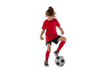 Portrait of little girl, child playing football, training, dribbling ball against transparent background. Sportive and active kid. Concept of action, team sport game, energy, vitality. © Lustre Art Group 