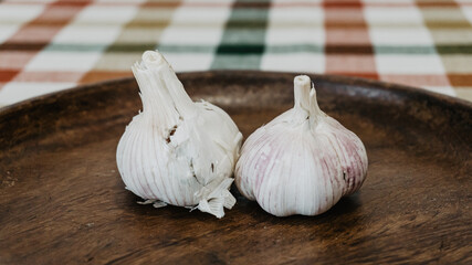 Delicious garlic on a kitchen acacia wood plate.