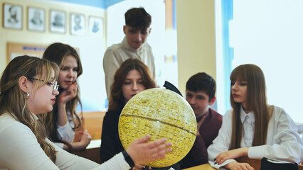 High school students looking at the yellow globe of the moon.