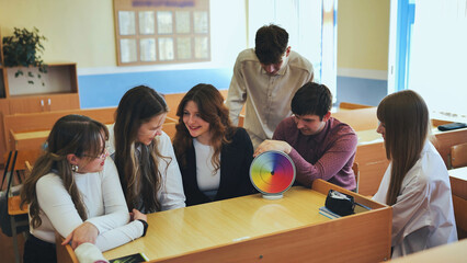 Students in physics class spin Newton's colorful wheel.
