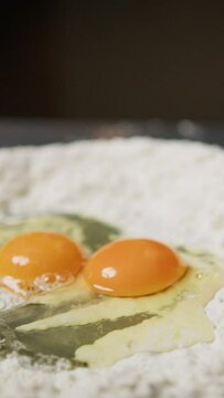 Hand Of Chef Cracking Eggs Into Flour For Dough Pasta Tagliatelle
