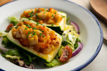 Zucchini stuffed with vegetables and fresh hake.