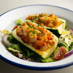 Zucchini stuffed with vegetables and fresh hake.