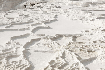 Detail of the natural terraced basins at Pamukkale, Turkey, showcasing the intricate white patterns...