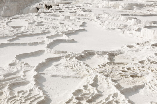 Detail of the natural terraced basins at Pamukkale, Turkey, showcasing the intricate white patterns and textures.