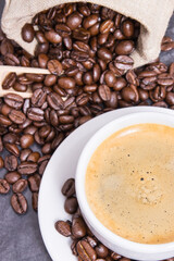 Coffee in white cup and roasted dark coffee beans