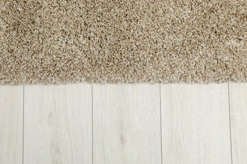 Soft beige carpet on white laminated floor indoors, top view. Space for text