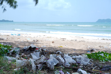 Pile of litter at the sandy beach, Plastic glass left on the beach, waste pollution or garbage on the beach background. Rubbish disposal and trash management, Environmental pollution concept.