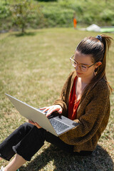Focused female entrepreneur using laptop to work remotely