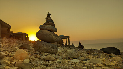 Chalets on the dead sea at sunset with rock stack