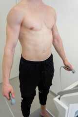 Athletic man engaging in body composition analysis at a health facility