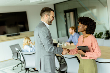 Professional handshake between colleagues in a modern office setting during daylight hours