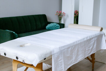 Massage therapist's office in light colors at spa salon. Massage bed. Anticellulite, sport, relaxing massage, spa therapy