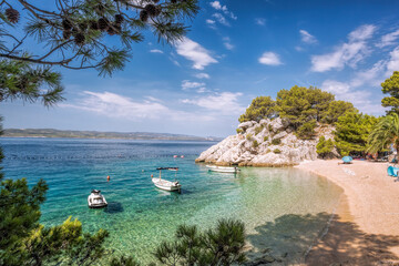 Amazing Punta Rata beach with boats against azure sea in Brela, Makarska, Dalmatia, Croatian azure...