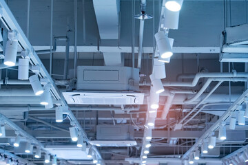 Directional LED lights on rails under the ceiling in a modern warehouse, shopping center building,...