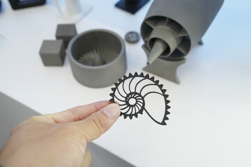 hand with metal shell object printed on 3d printer close-up