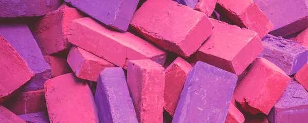 Clay handmade bricks. Abstract pile of bricks background. Bright magenta-purple colored. Horizontal banner
