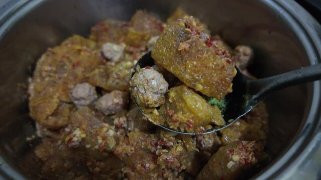 Someone is cooking Sambel Goreng Krecek that made from buffalo or cow skin using a pot. Concept for Indonesian Eid al fitr celebration.