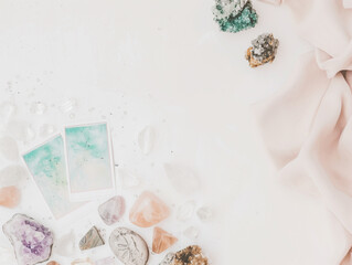 Tarot cards and healing crystals on a white beach in the sun